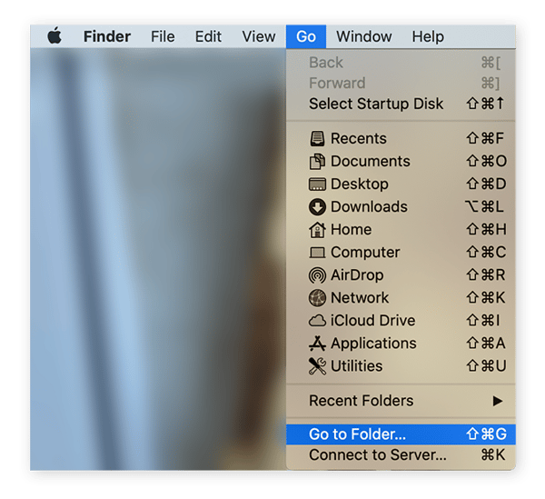 The home screen of a Mac computer with 'Go' selected from the top Finder menu bar. This results in a drop down menu, 'Go to Folder' is selected from this drop down menu.