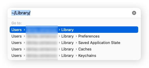 The Go to Folder text box on macOS Sonoma, depicting the command for the Library folder.